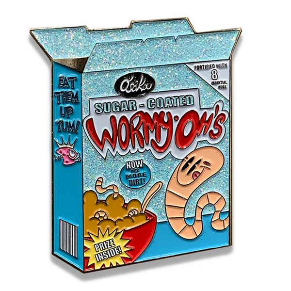 Cartoon cereal box with playful worm character on Wormy Oh’s Glitter Cereal Box Enamel Pin